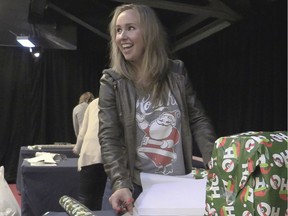 Julie Petry wraps gifts for  underprivileged youngsters as part of the Canadiens' annual Opération Père Noël program at the Bell Centre in Montreal Tuesday, Dec. 15, 2015.