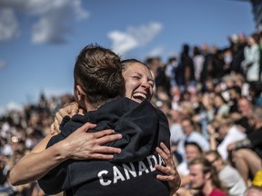 Jessica Macaulay (R) of Canada celebrates with her coach Stephane Lapointe of Canada after diving from the 21.5 metre platform at the Copenhagen Opera House during the final competition day of the third stop of the Red Bull Cliff Diving World Series on July 16, 2022