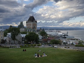 Visitors sit on the hillside around the Citadelle of Quebec on July 26, 2022 in Quebec City. Pope Francis is scheduled to give public remarks this week at the historic site, a star-shaped fortress overlooking the St. Lawrence River and the old city, as part of his “pilgrimage of penance.