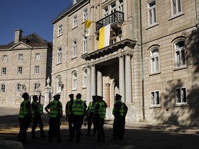 Police stand watch outside the Archdiocese of Quebec in Quebec City ahead of the visit by Pope Francis on July 27, 2022, in Quebec City.