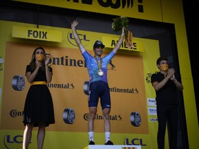 Quebec's Hugo Houle celebrates on the podium after winning the 16th stage of the Tour de France cycling race on Tuesday, July 19, 2022.