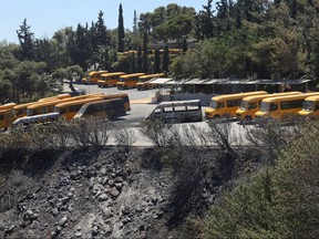 Burned school busses are seen at the parking lot of a school in Palini near Athens, Greece, July 20, 2022.