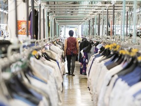 A garment worker walks through a clothing factory in Montreal. The number of workers over 65 in Quebec has grown from 169,800 in 2019 to 194,100 by May 2022.