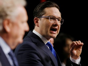 Conservative Party leadership front-runner Pierre Poilievre speaks during a debate in May as Jean Charest looks on.