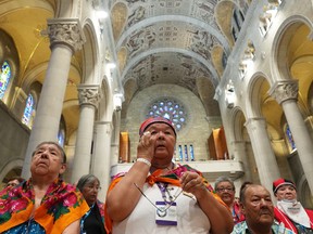 An Indigenous woman wipes a tear during a mass with Pope Francis at the Ste-Anne-de-Beaupré basilica on Thursday, July 28, 2022.