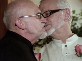 Roger Thibault (left) and Theo Wouters (right) seal their marriage with a kiss at the reception held in their honour at SKY PUB on Ste-Catherine St. on July 18, 2002.