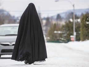 A female member of the ultra-orthodox Jewish sect Lev Tahor, walks down a street in Ste-Agathe-des-Monts in 2013. Women in the sect are covered from head to toe at all times.