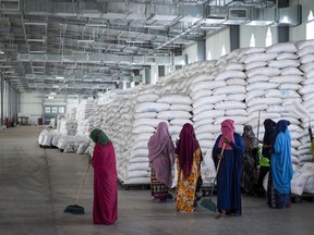 Workers clean the floor as sacks of food earmarked for the Tigray and Afar regions sit in piles in a warehouse of the World Food Programme (WFP) in Semera, the regional capital for the Afar region, in Ethiopia on Feb. 21, 2022.