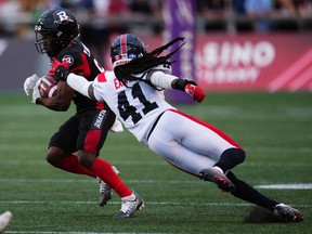 Alouettes defensive-back Kerfalla Exumé tries to stop Redblacks wide-receiver Terry Williams during game in Ottawa last Thursday.