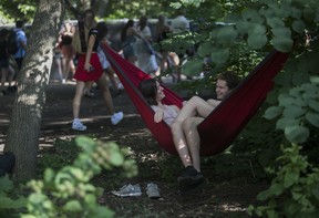 Elisabeth Alexander and Brady Hales of Thunder Bay, Ontario brought their own hammock and found a spot to chill on Day 1 of the Osheaga festival at Parc Jean-Drapeau in Montreal Friday, July 29, 2022.