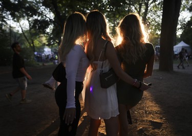 Women pose for a photo as the sun set  on the last day of the Osheaga festival at Parc Jean-Drapeau on July 31, 2022.