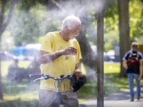 Edward Prest cools off at a misting station on Mont-Royal Ave. on a humid day in Montreal, Tuesday July 12, 2022.