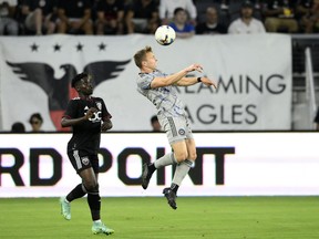 آلیستر جانستون، مدافع CF مونترال، سمت راست، در نیمه اول یک مسابقه فوتبال MLS، شنبه، 23 ژوئیه 2022، در واشنگتن، در مقابل مدافع دی سی یونایتد، گائوسو ساماکه، شیرجه می زند.