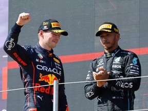 Red Bull's Max Verstappen celebrates on the podium after winning the race alongside second place Mercedes' Lewis Hamilton on July 24, 2022.