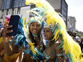 Artists stop for a selfie as they take part in the Carifiesta Parade in Montreal, Saturday, July 2, 2022.