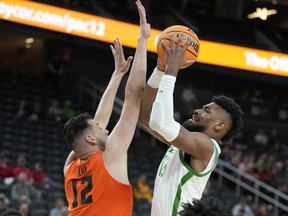 Oregon's Quincy Guerrier, who hails from Montreal, shoots against Oregon State's Roman Silva during the Pac-12 tournament in March. Oregon will be one of the NCAA teams playing in Montreal next month.