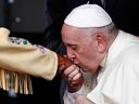 Pope Francis kisses the hand of Alma Desjarlais of Frog Lake First Nation during a welcome ceremony after arriving at Edmonton International Airport on Sunday. 