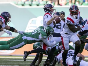 Saskatchewan Roughriders defensive lineman Anthony Lanier II (91) knocks the ball loose from Montreal Alouettes quarterback Trevor Harris (7) during first half CFL action at Mosaic Stadium on Saturday, July 2, 2022 in Regina.