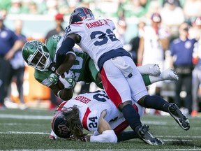 Saskatchewan Roughriders running back Frankie Hickson (20) is tackled by Montreal Alouettes corner back Rodney Randle Jr. (32) during first half CFL action at Mosaic Stadium on Saturday, July 2, 2022 in Regina.