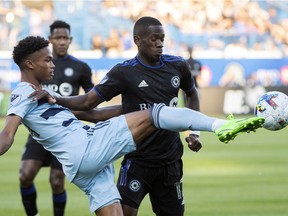 Sporting KC's Kayden Pierre, left, clears the ball from CF Montréal's Jojea Kwizera during first half MLS soccer action in Montreal on Saturday, July 9, 2022.