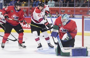 Team White’s Nathan Gaucher of the Quebec Remparts tries to tip the puck past Team Red goalie Reid Dyck of the Swift Current Broncos during the 2022 Kubota CHL/NHL Top Prospects game in Kitchener, Ontario on Wednesday, March 23, 2022.