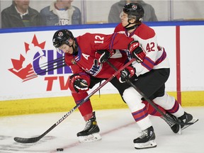 Maveric Lamoureux, left, of the Drummondville Voltigeurs fights for possession against Reid Schaefer of the Seattle Thunderbirds during the 2022 Kubota CHL/NHL Top Prospects game in Kitchener, Ont., on Wednesday, March 23, 2022.