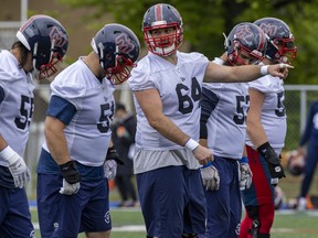 Alouettes centre Sean Jamieson, 64, points out defensive assignments to fellow offensive linemen during training camp in May 2022.