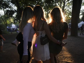 Friends pose for a photo as the sun set on the last day of the Osheaga festival at Parc Jean-Drapeau in Montreal Sunday, July 31, 2022.