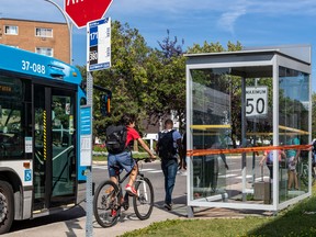 Montrealers walk past the bus stop in St-Laurent where a man was shot and killed on Tuesday night.