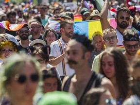 People walk along Ste-Catherine St. E. in Montreal Sunday, Aug. 7, 2022. This was during a protest march that was made after the Pride Parade was cancelled.