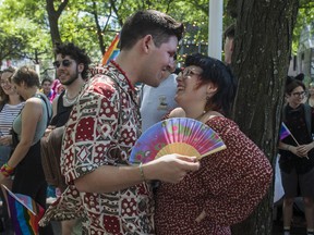 Oscar Hogan-Paul fans Kleo Hellman in Place Emilie-Gamelin in Montreal Sunday, August 7, 2022. This was prior to a protest march that was made after the Pride Parade was cancelled.