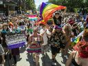 People march on Ste-Catherine St. in the Gay Village area of Montreal on Sunday, August 7, 2022 after the Pride parade was cancelled.