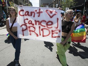 Laurence Hanley, left, and Fanilou Laniel Gauld speak for many in the crowd on Ste-Catherine St. in the Gay Village area of Montreal Sunday, Aug. 7, 2022 during 
a march after the Pride parade was cancelled.