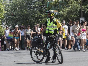 A police officer diverts vehicle traffic on Sherbrooke St. E. in Montreal Sunday, Aug. 7, 2022. This was during a protest march that was made after the Pride Parade was cancelled.