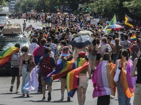 People walk along Sherbrooke St. E. in Montreal Sunday, Aug. 7, 2022, during a protest march that was made after the Pride Parade was cancelled.