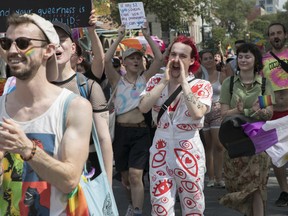 People walk along St-Laurent Blvd. in Montreal Sunday, Aug. 7, 2022. This was during a protest march that was made after the Pride Parade was cancelled.
