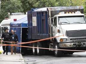 Montreal police officers at the scene of a suspicious death, after a body was found in garbage truck making its rounds on Adam St. on Monday Aug. 8, 2022.