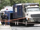 Polizisten aus Montreal am Tatort eines verdächtigen Todesfalls, nachdem am Montag, den 8. August 2022, eine Leiche in einem Müllwagen gefunden wurde, der in der Adam St. seine Runden drehte.