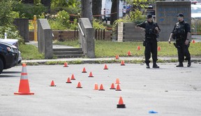 Montreal police examine a crime scene at Lester B Pearson High School in Montreal North Aug. 11, 2022. A 26-year-old man died a the shooting Wednesday night.