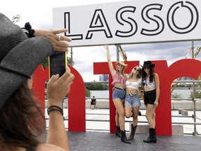 Friends Melissa, from left, Brooklyn and Samatha pose for a photo during the Lasso country music festival in Montreal on Friday, Aug. 12, 2022.