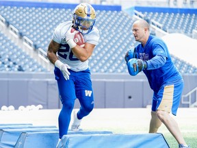 Blue Bombers running-backs coach Jason Hogan spends time with Canadian tailback Brady Oliveira during practice.