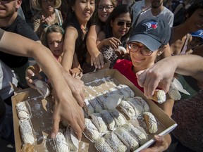 People crowd around Victoria Scarola to get a free cannoli at a Montreal Italian Week event in 2017. This summer, ItalfestMTL runs Aug. 5 to 20.