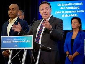 Quebec Premier Francois Legault, surrounded by CAQ candidates in upcoming Quebec elections, speaks to the press in Laval, Quebec, on Friday, August 12, 2022.