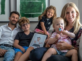 From left: Michael Hollander, 10-year-old Ari Hollander, seven-year-old Lielle Hollander and Dahlia Guttman with one-year-old Levana Hollander. In the framed photo is Ronnie Joy Hollander, who died in January 2020 at the age of 27 months.