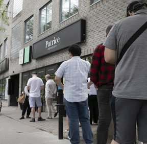 Customers line up outside Patrice Pâtissier to pick up orders they made online, Thursday, Aug. 18, 2022, during the final days of the pastry shop.