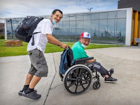 A friend from Kangirsujuaq pushes Jaipiti Jaaka in his wheelchair outside the Ullivik residence in Dorval on Monday Aug. 22, 2022.