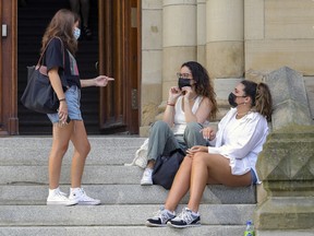 Friends gather on the steps of Dawson College on the first day of the CEGEP school year on Aug. 23, 2021.