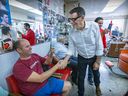 Éric Duhaime greets a customer at a barber shop in Montreal North Thursday, Aug. 25, 2022. “It’s very long and tough to develop a political brand,” Duhaime said of starting a party from scratch. “The Conservative party is a known brand.”