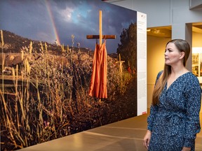 Photojournalist Amber Bracken looks at her award-winning photo of residential school graves at the World Press Photo exhibit at Marché Bonsecours in Montreal on Monday, Aug. 29, 2022.