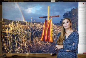 Photojournalist Amber Bracken stands with her award-winning photo of residential school graves at the World Press Photo exhibit at Marché Bonsecours in Montreal on Monday, Aug. 29, 2022.